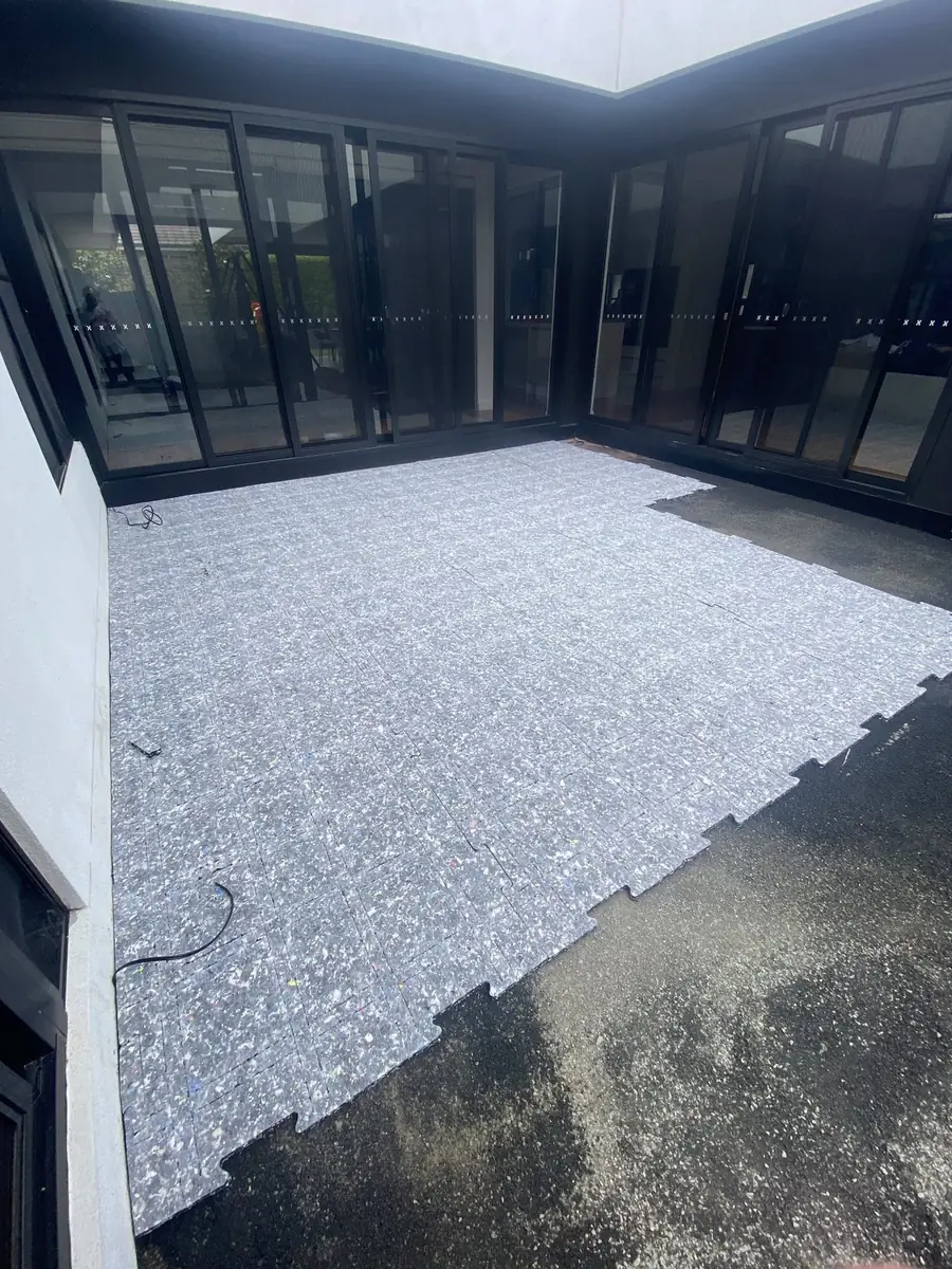 Shock pad underlay laid over a concrete courtyard